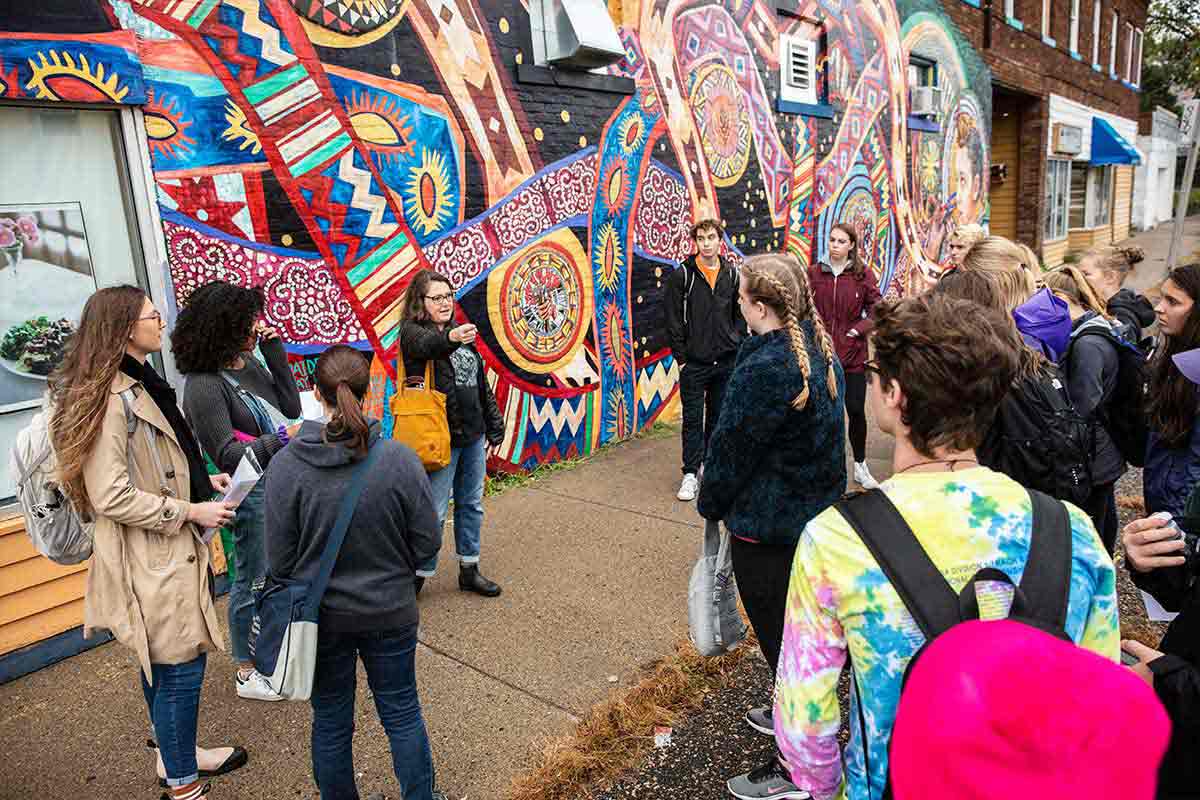 Dr. Heather Shirey teaches an art history class in front of a mural in the Midway neighborhood of St. Paul.