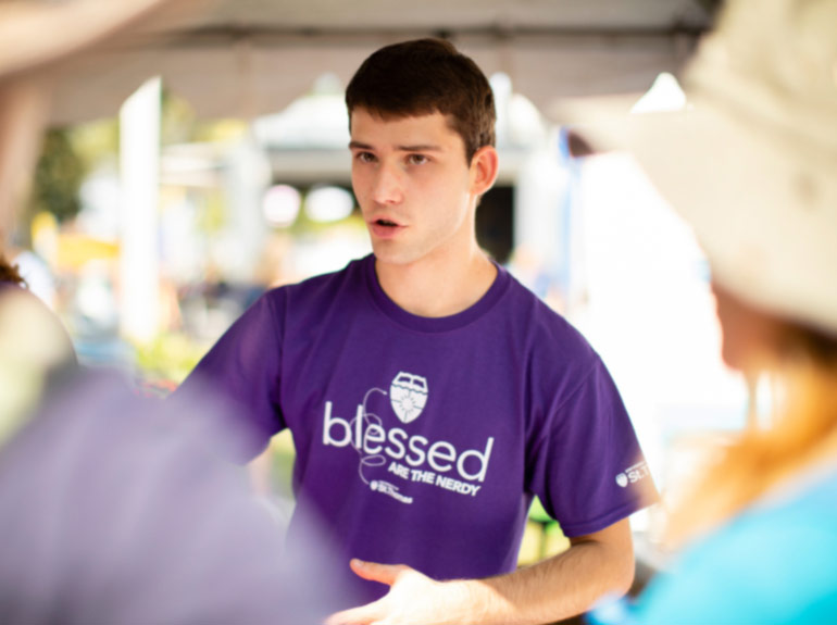 Student speaks with guests at the STEM Booth at the Minnesota State Fair. 