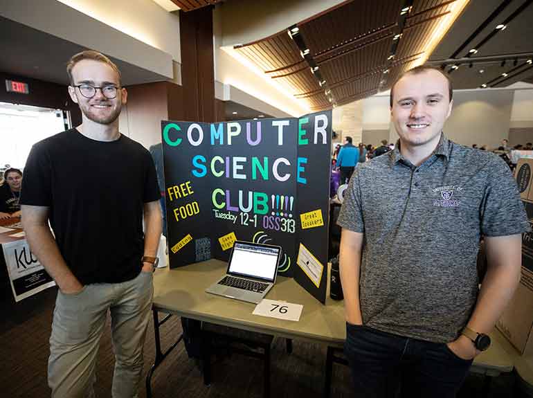 Computer Science Club students pose for a photo in front of their display at the Spring Activities Fair.