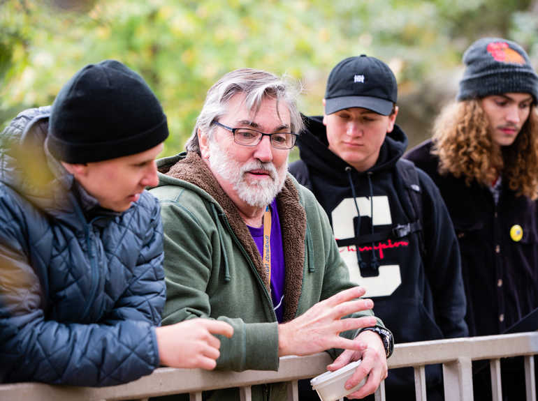 Professor Thomas Hickson talks with students outdoors