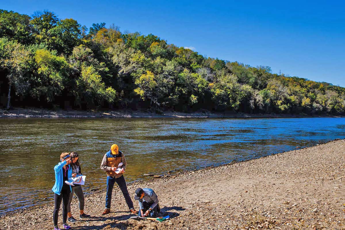 Students in the Sustainability LLC work together on a project by the Mississippi River. 