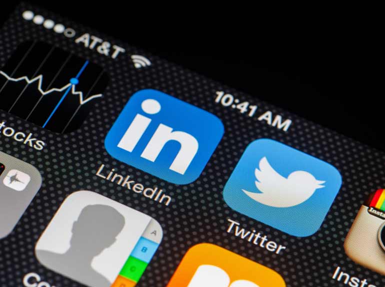 Stock photo of an iPhone screen featuring apps for LinkedIn, Twitter and Instagram.
