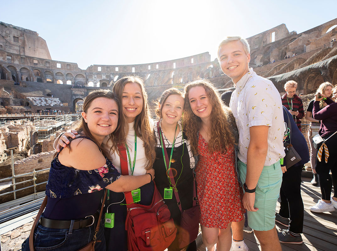 College of Arts and Sciences students on a study abroad program in Rome, Italy pose for photos while on a tour of the Colosseum.