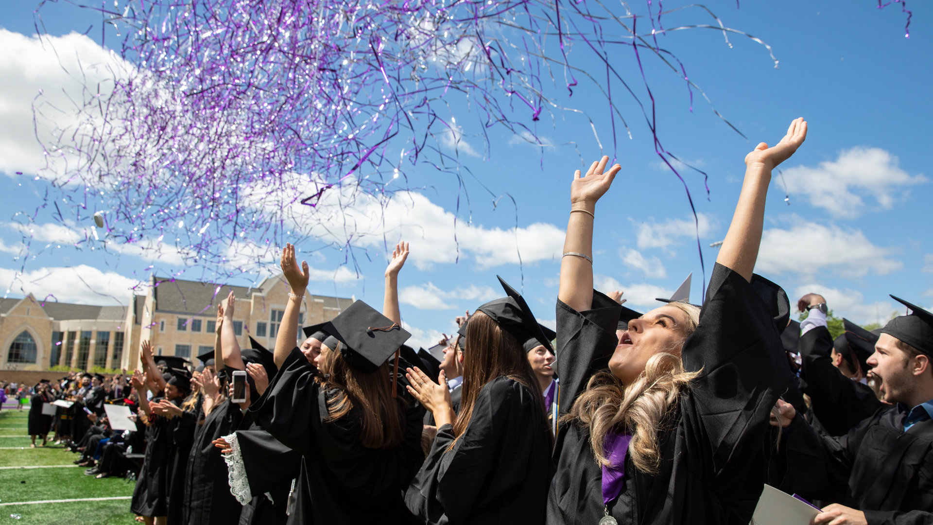 Students celebrate as confetti falls during Commencement