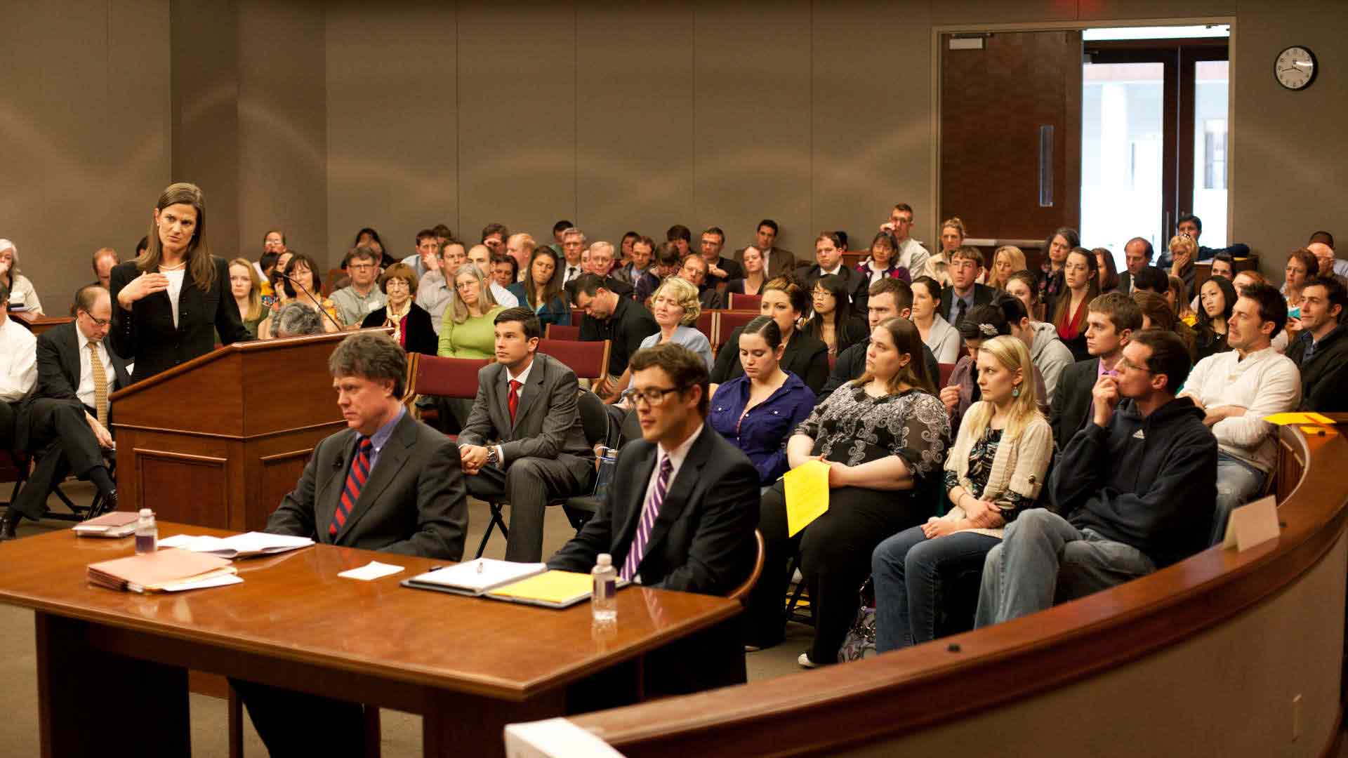 Environmental photo of a group sitting in a courtroom during a mock trial.