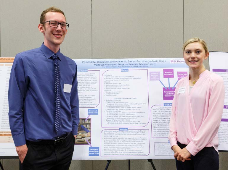 Students pose in front of their poster during the Undergraduate Research Poster Session. 