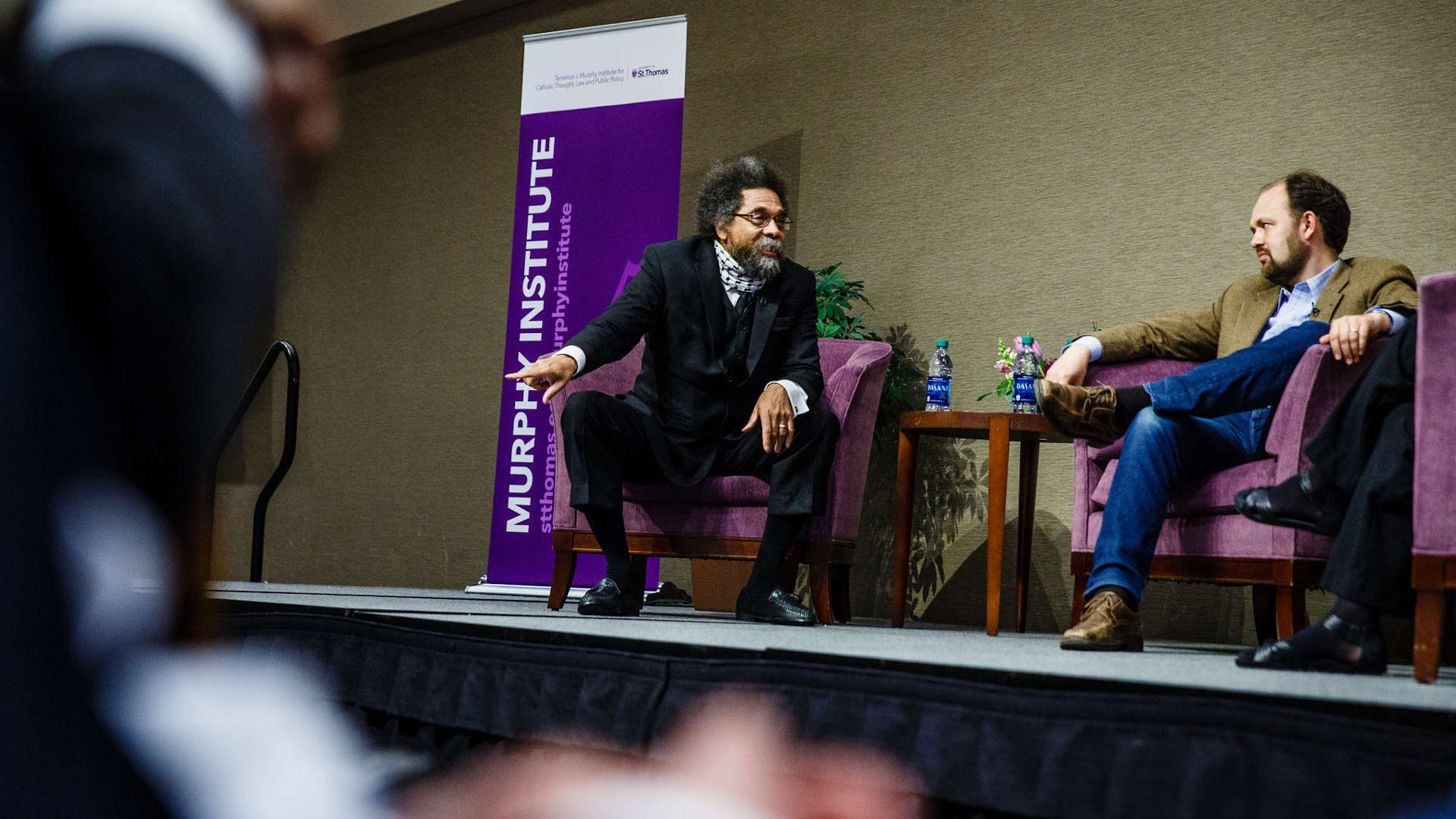 Cornell West and Ross Douthat talk during a panel discussion.