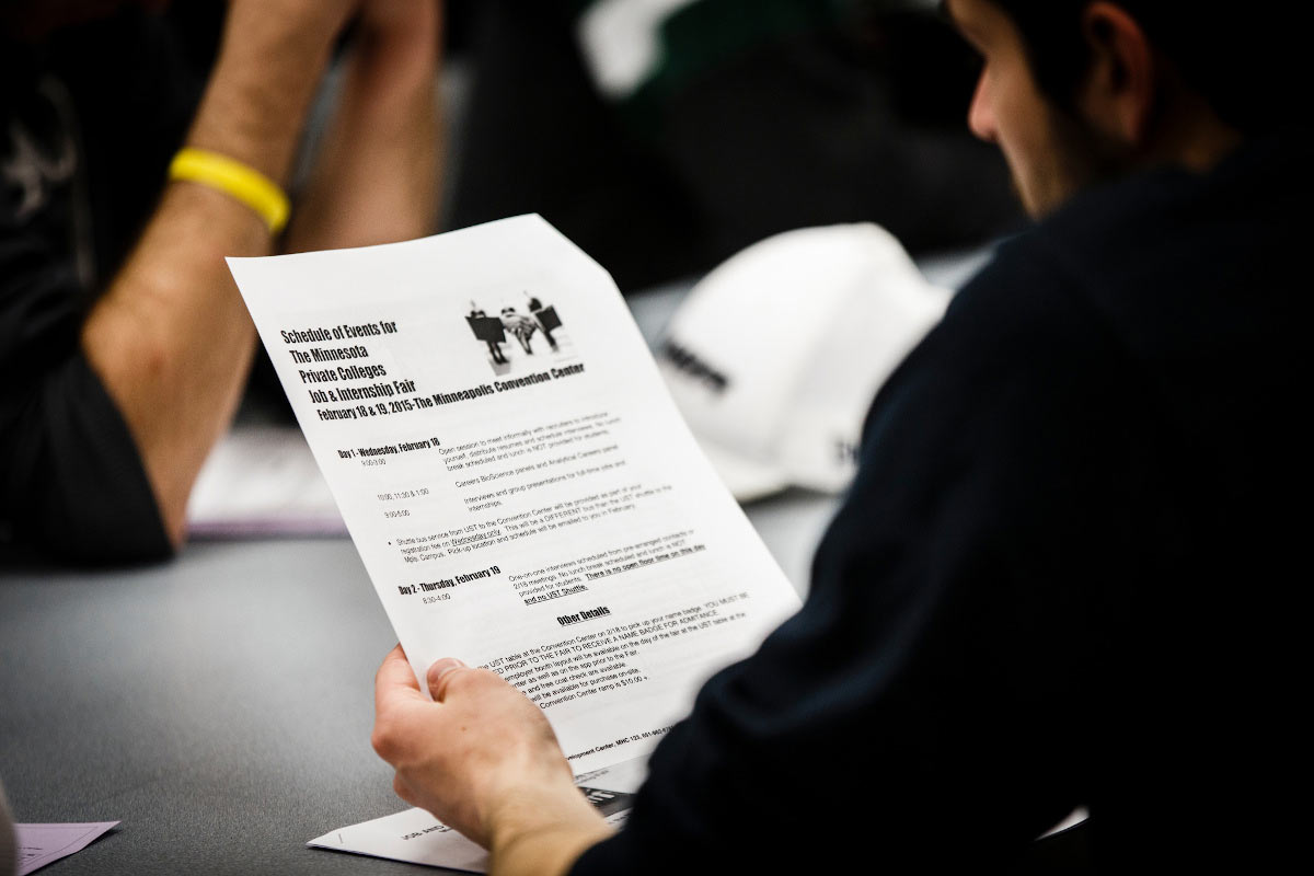 A student looks over an itinerary for the Minnesota Private College Job Fair as part of a Career Development Center seminar. 