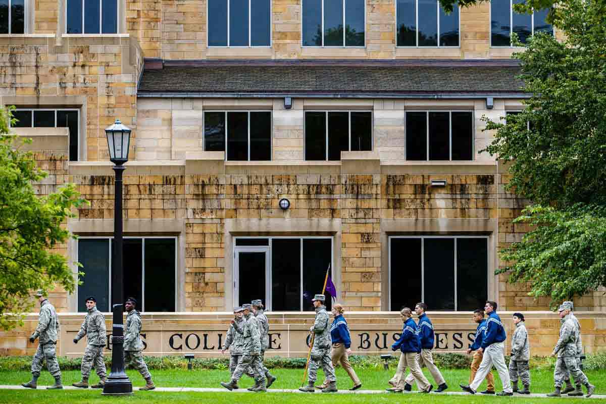 A group of cadets walk past Saint Thomas McNeely Hall.