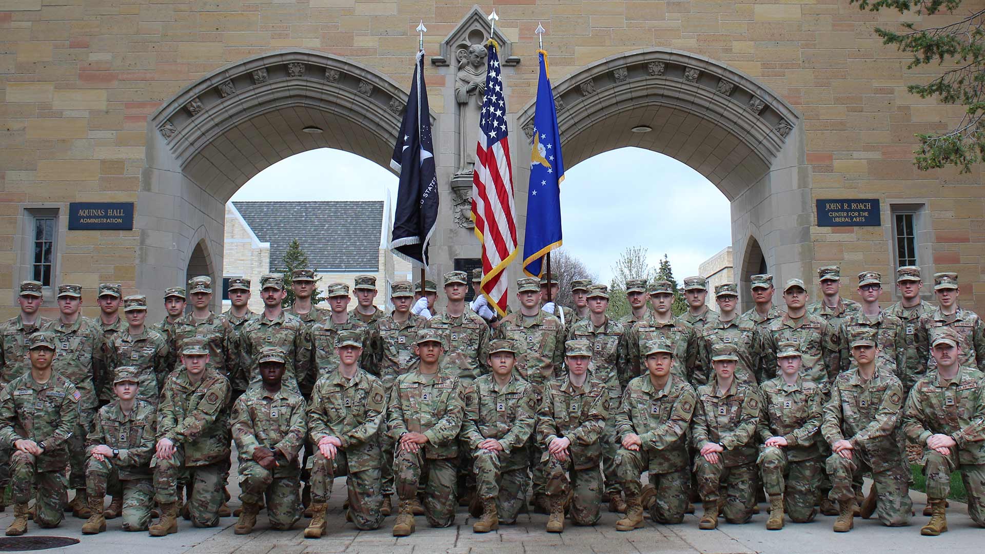 A group of cadets pose in front of the St. Thomas arches