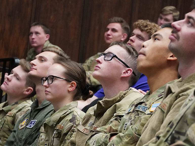 A group of cadets stand in the classroom