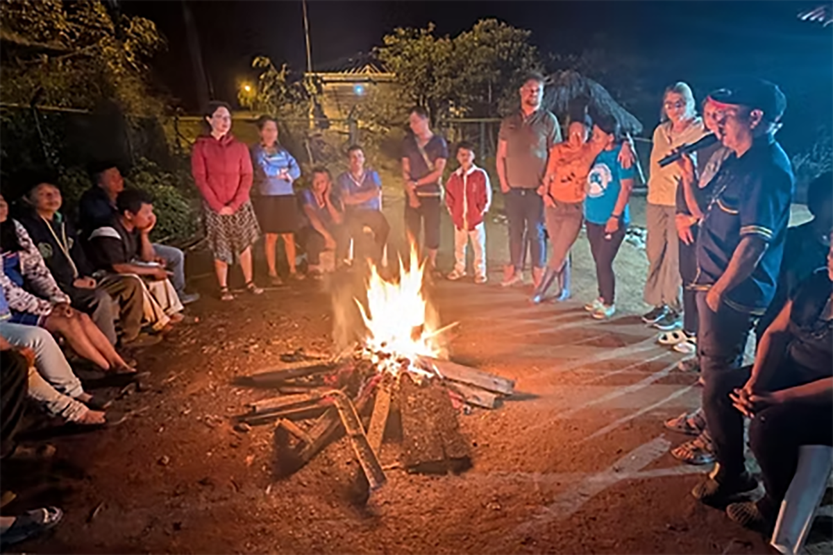 Trip members gather around a large bonfire