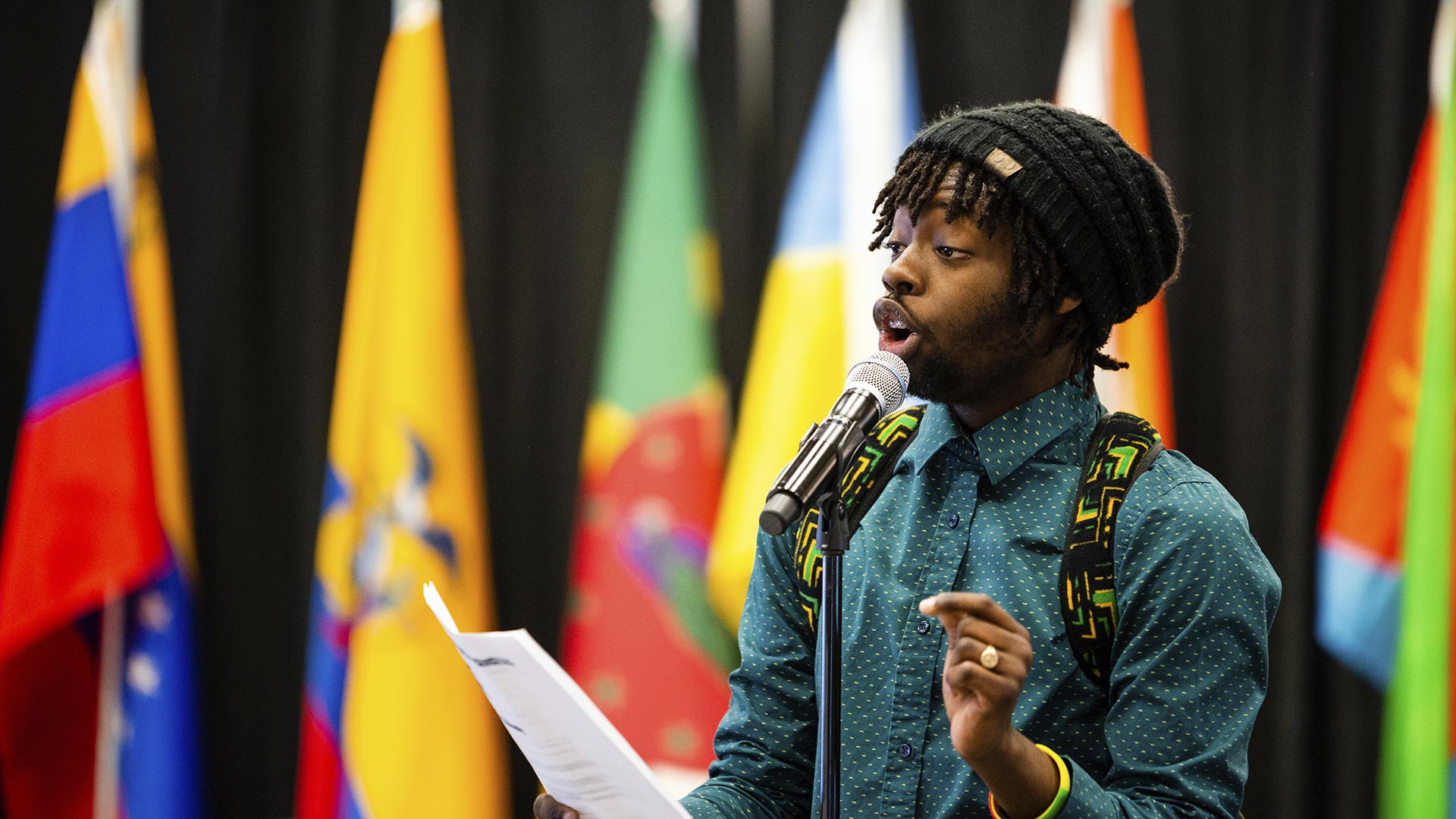 Student Keanu Daly speaks into a microphone during a public presentation