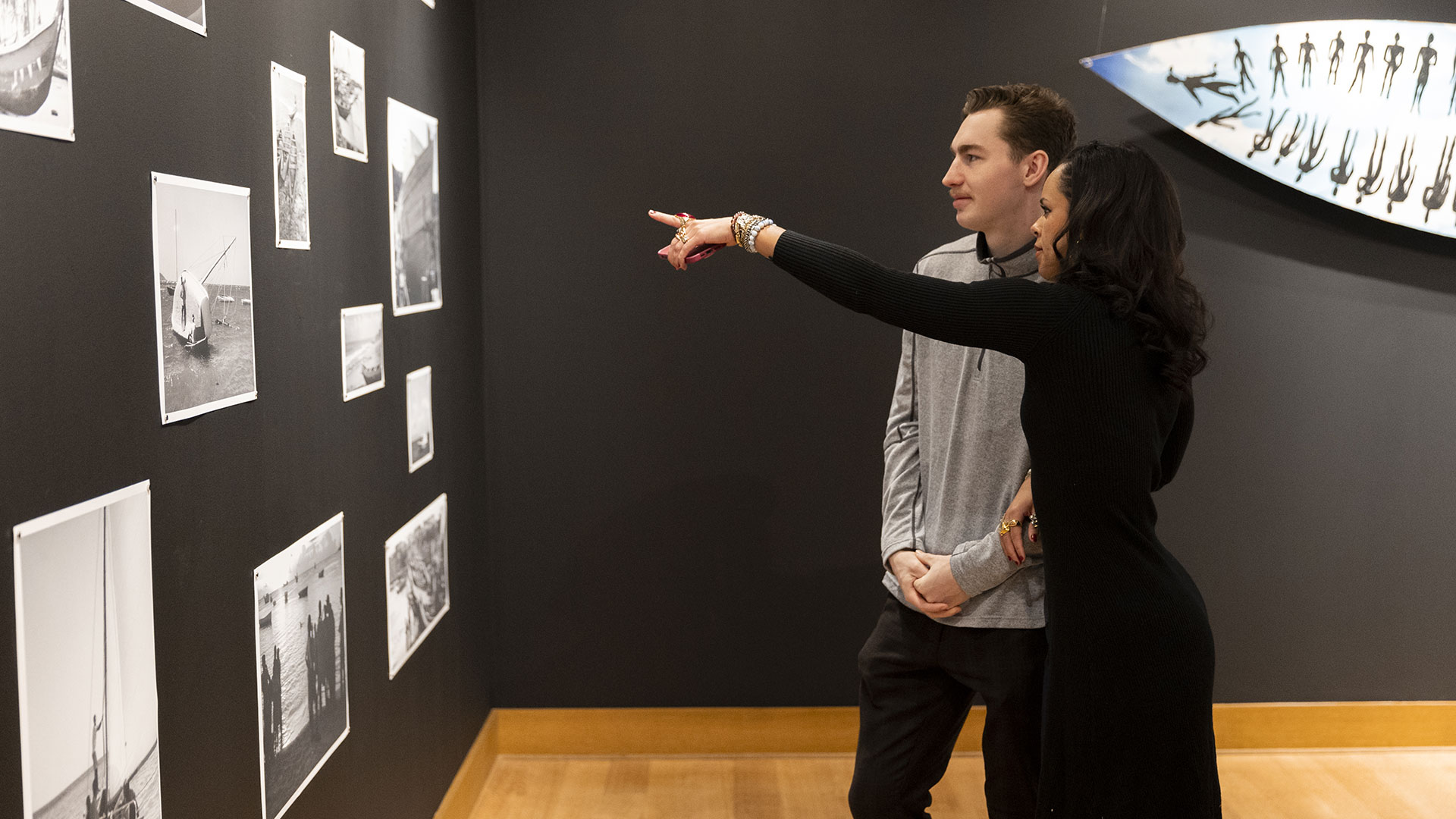 Patrons discuss photographs at the Seitu K., Jones exhibit in the Monahan Gallery