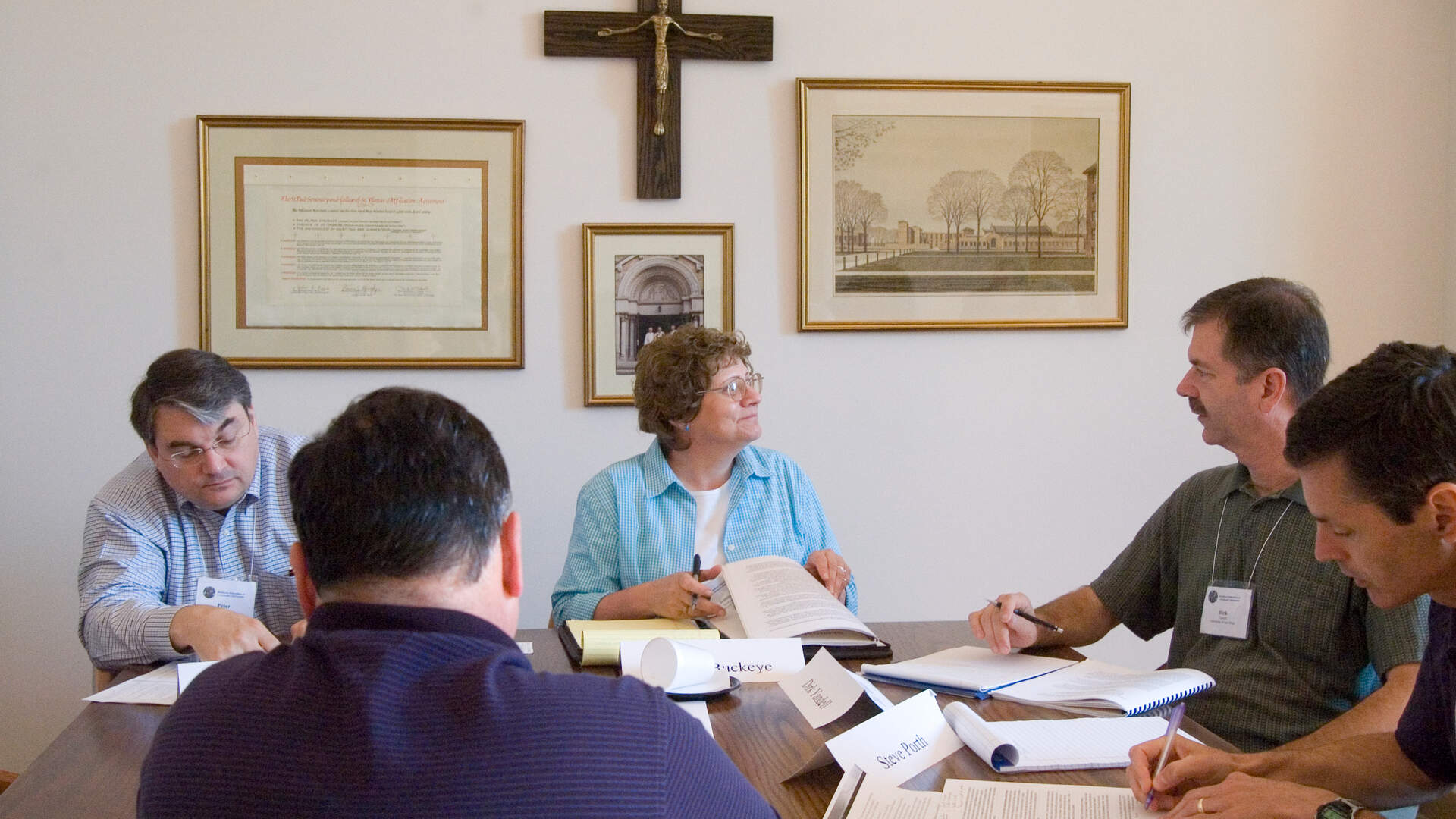 Business conference participants engaged in small groups in Sitzmann Hall Common Room