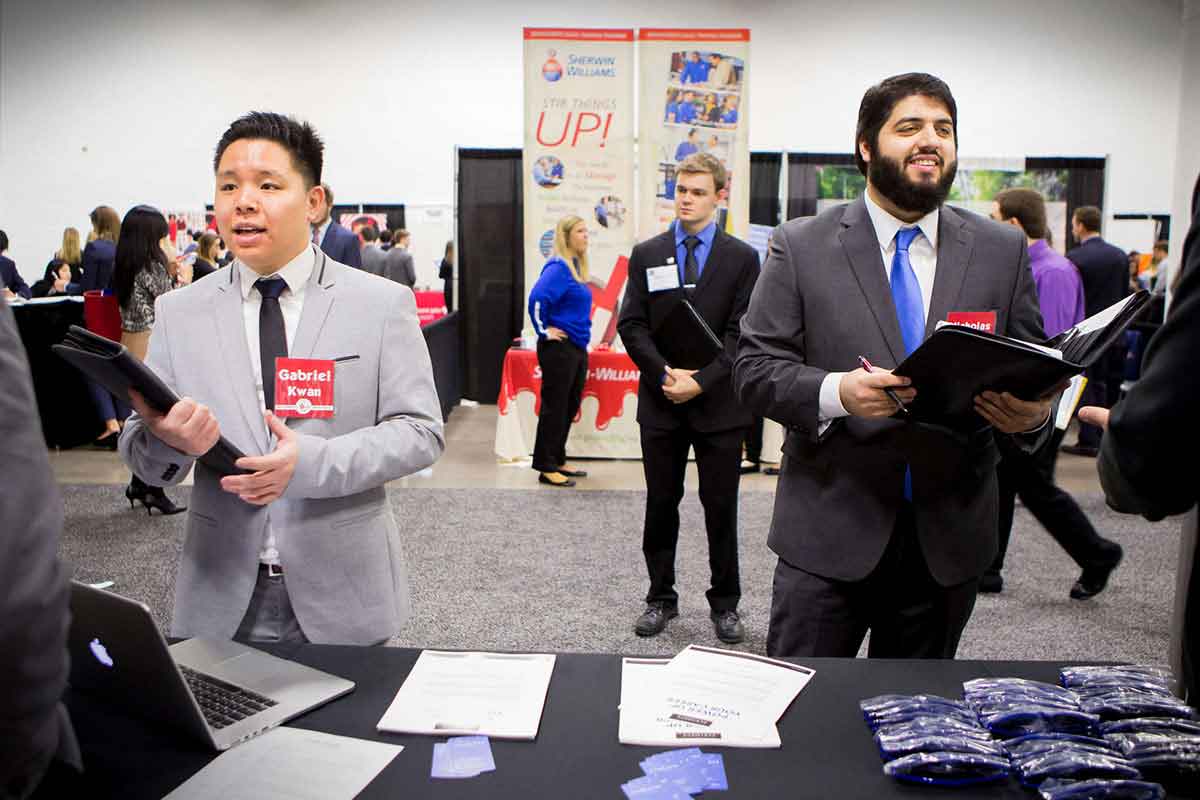 Two students speak to recruiters at the Minnesota Private Colleges Job Fair. 
