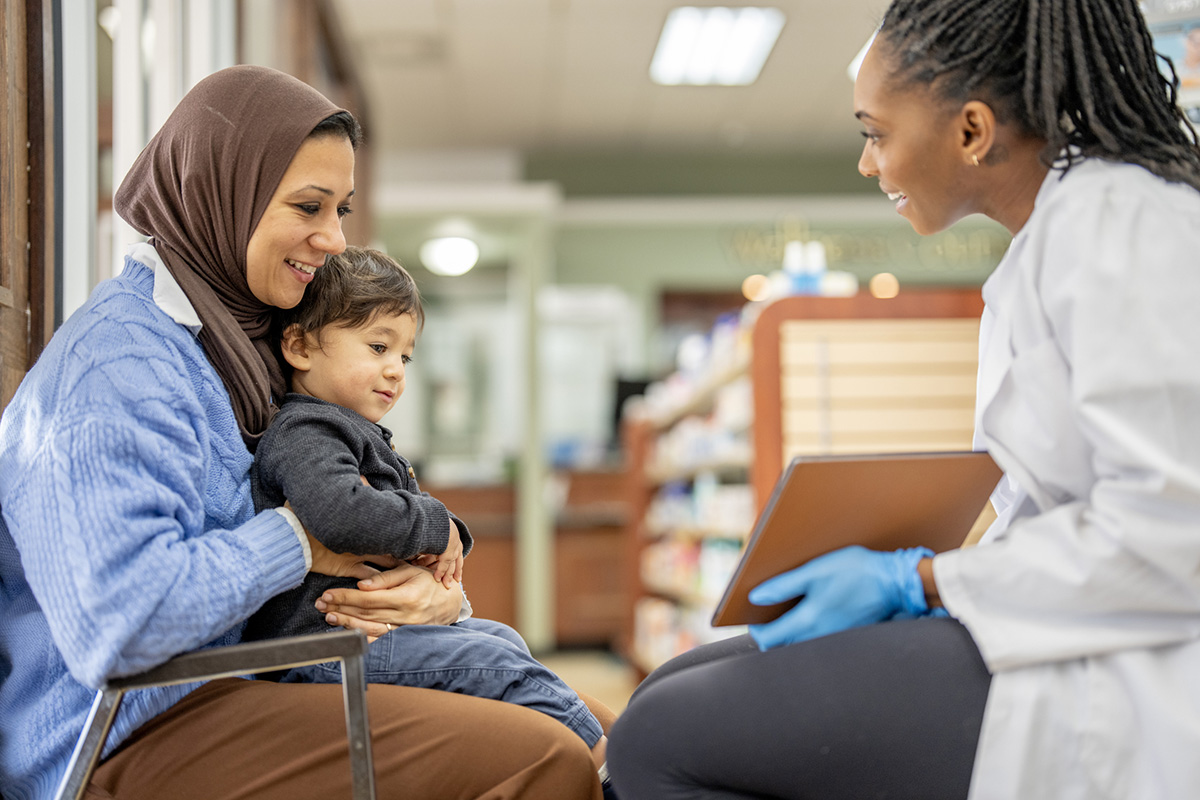 A doctor speaks with a woman and her child