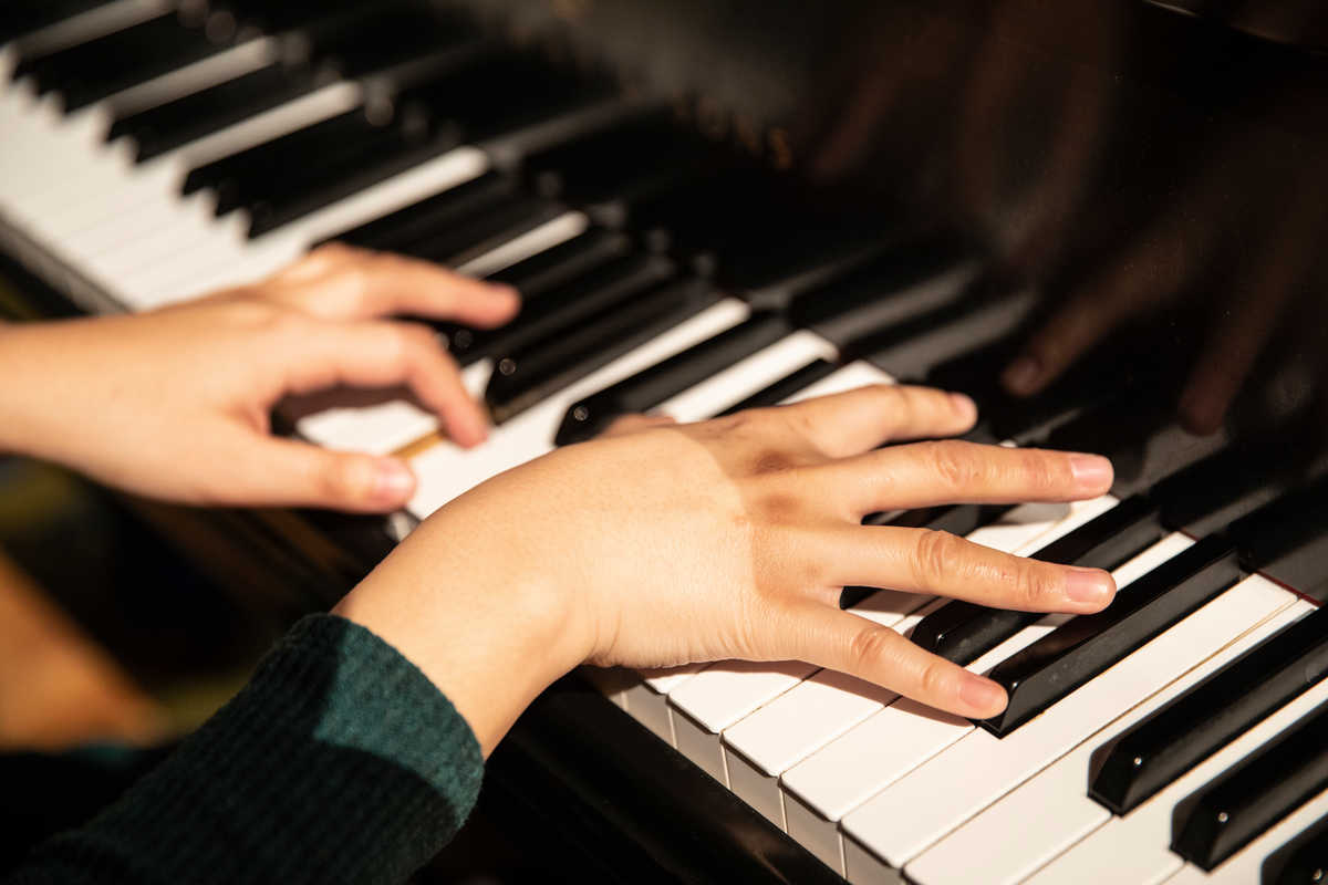 Hands playing the piano.