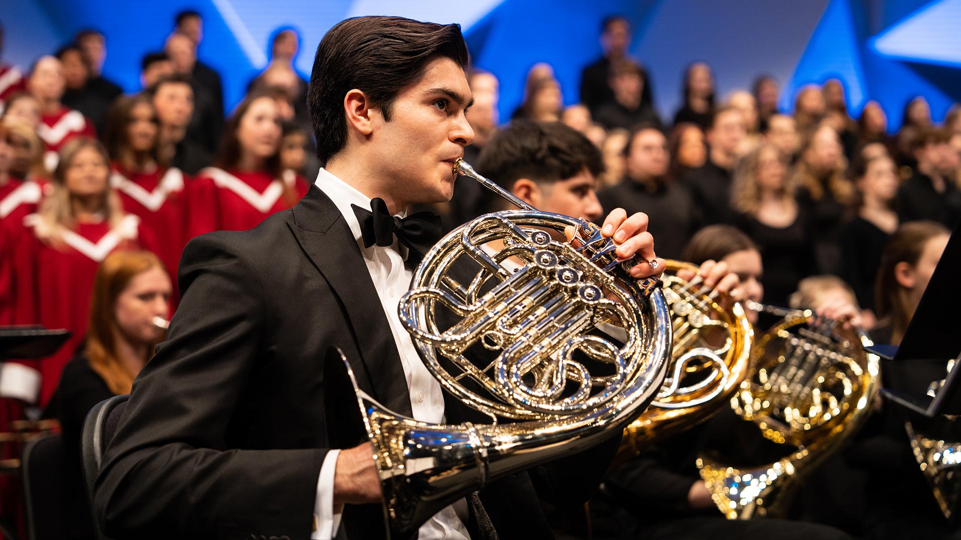 A student with a french horn performs at Orchestra Hall