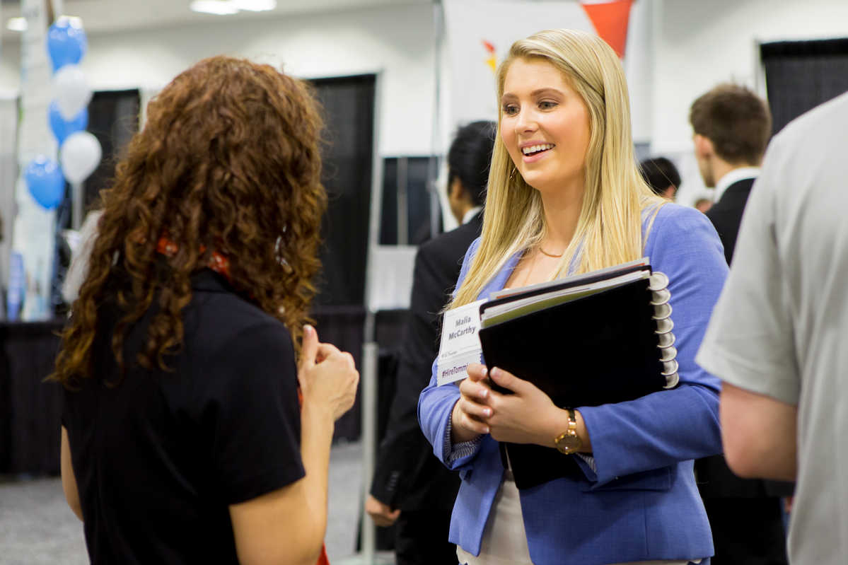 Two students speak to recruiters at the Minnesota Private Colleges Job Fair.