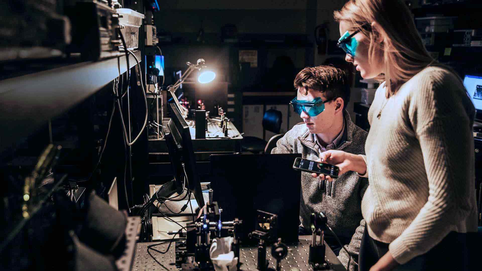 Two students work on a project involving lasers in a lab.