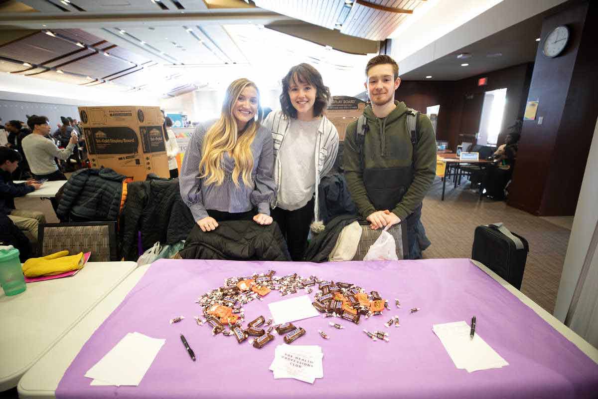Students pose for a photo at the Pre-Health Professions Club table at the Spring Activities Fair. 