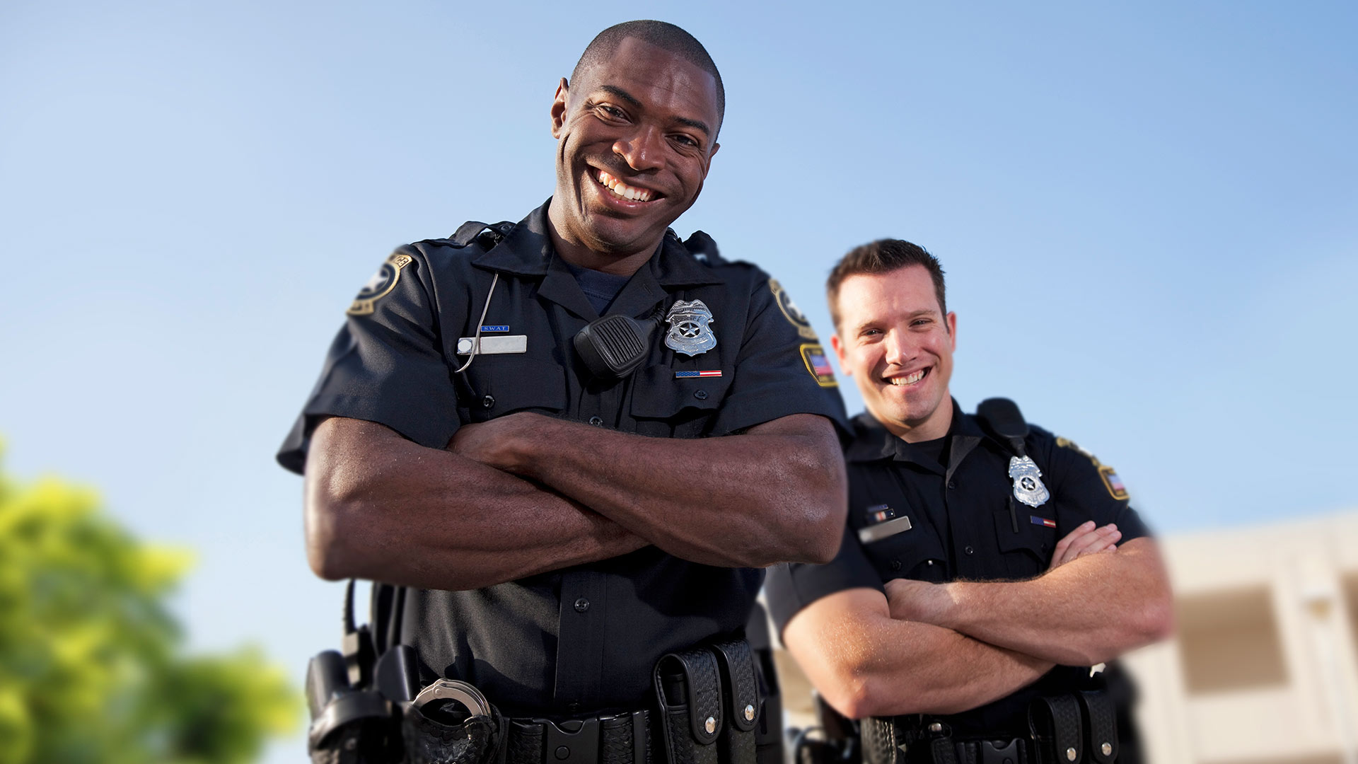 Police officers smiling outside.