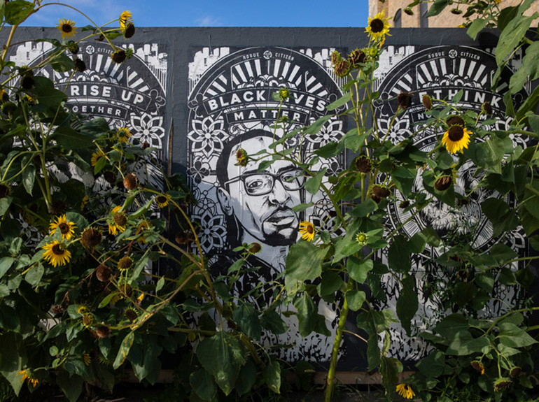 Black Lives Matter mural surrounded by sunflowers